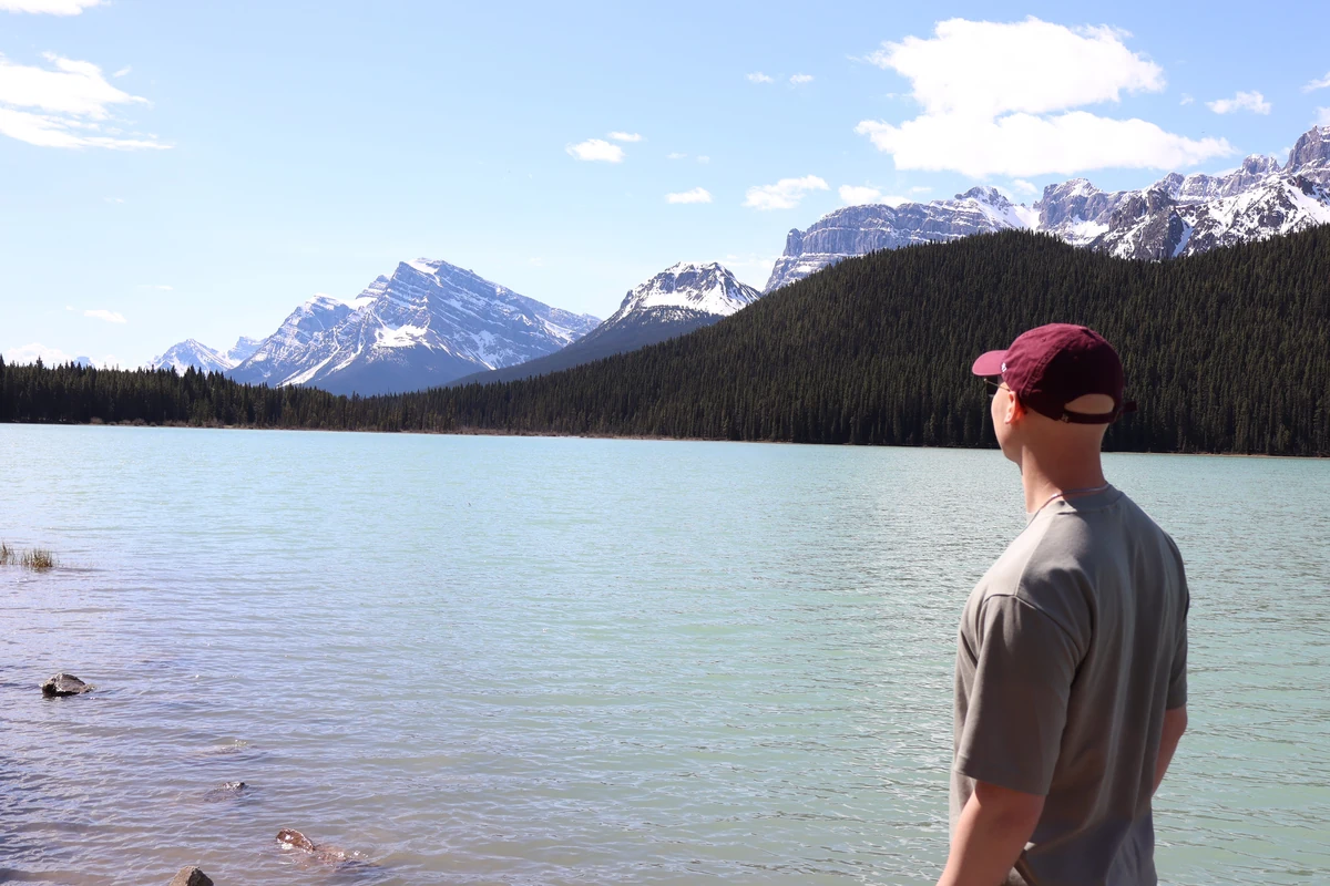 Alexander Ingare looking out across a glacial lake toward snow-capped peaks